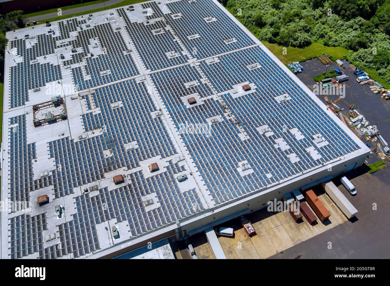 La vista panorámica de los paneles solares en el techo de la fábrica absorbe la luz del sol como fuente de energía para generar electricidad creando energía sostenible Foto de stock