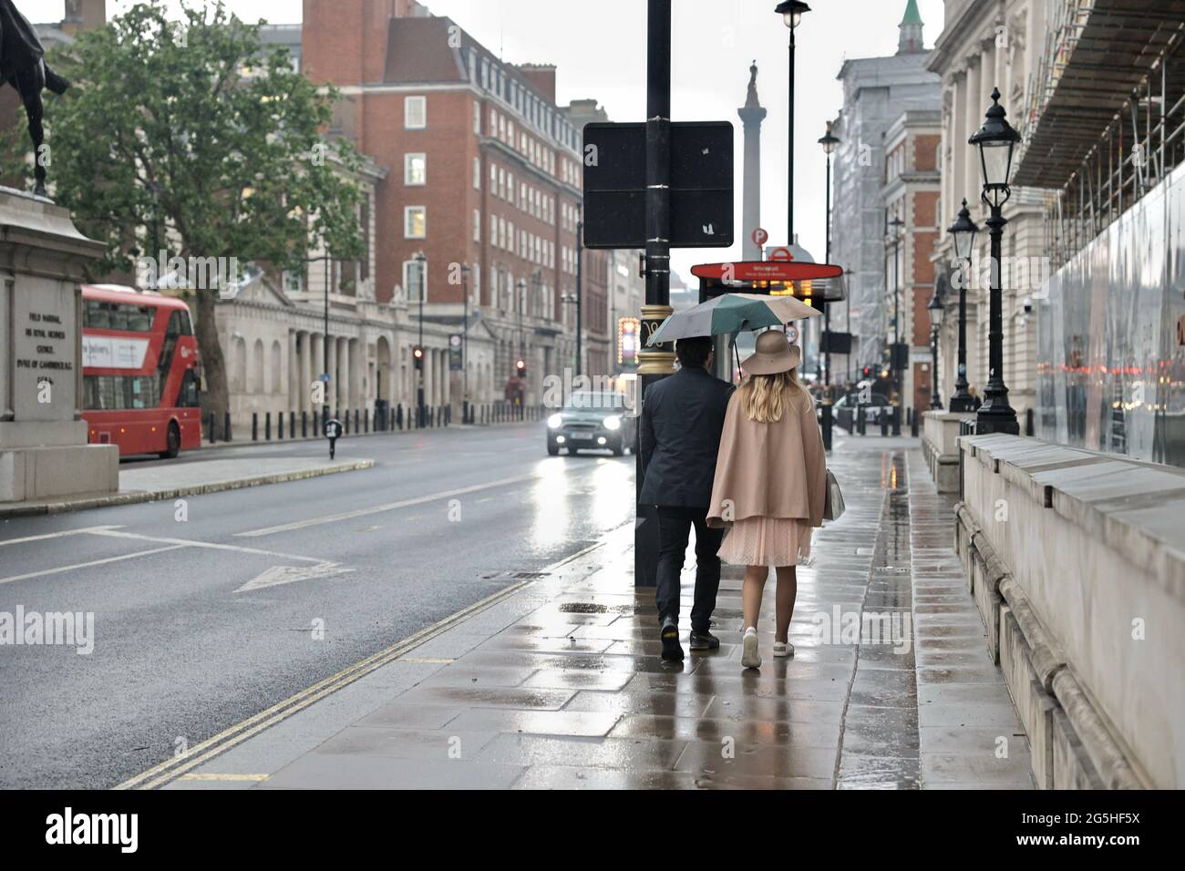Londres, Reino Unido. 27th de junio de 2021. Una pareja usando un paraguas mientras camina en el rain.London se espera tener una lluvia interminable para los próximos días antes de que la ola de calor golpea. (Foto de Hesther ng/SOPA Images/Sipa USA) Crédito: SIPA USA/Alamy Live News Foto de stock