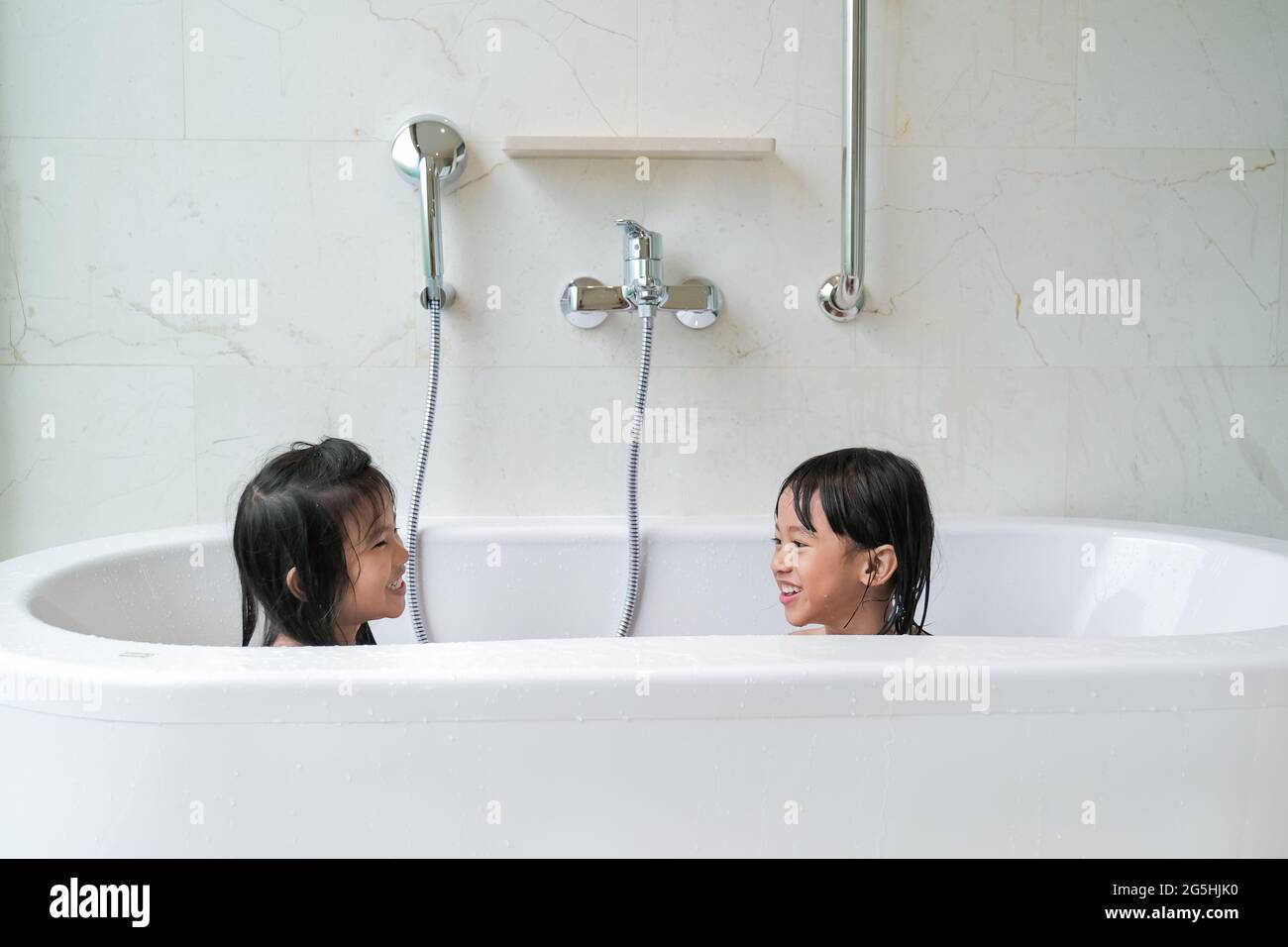 dos chicas felices tomando un baño juntos en una bañera Fotografía de stock  - Alamy