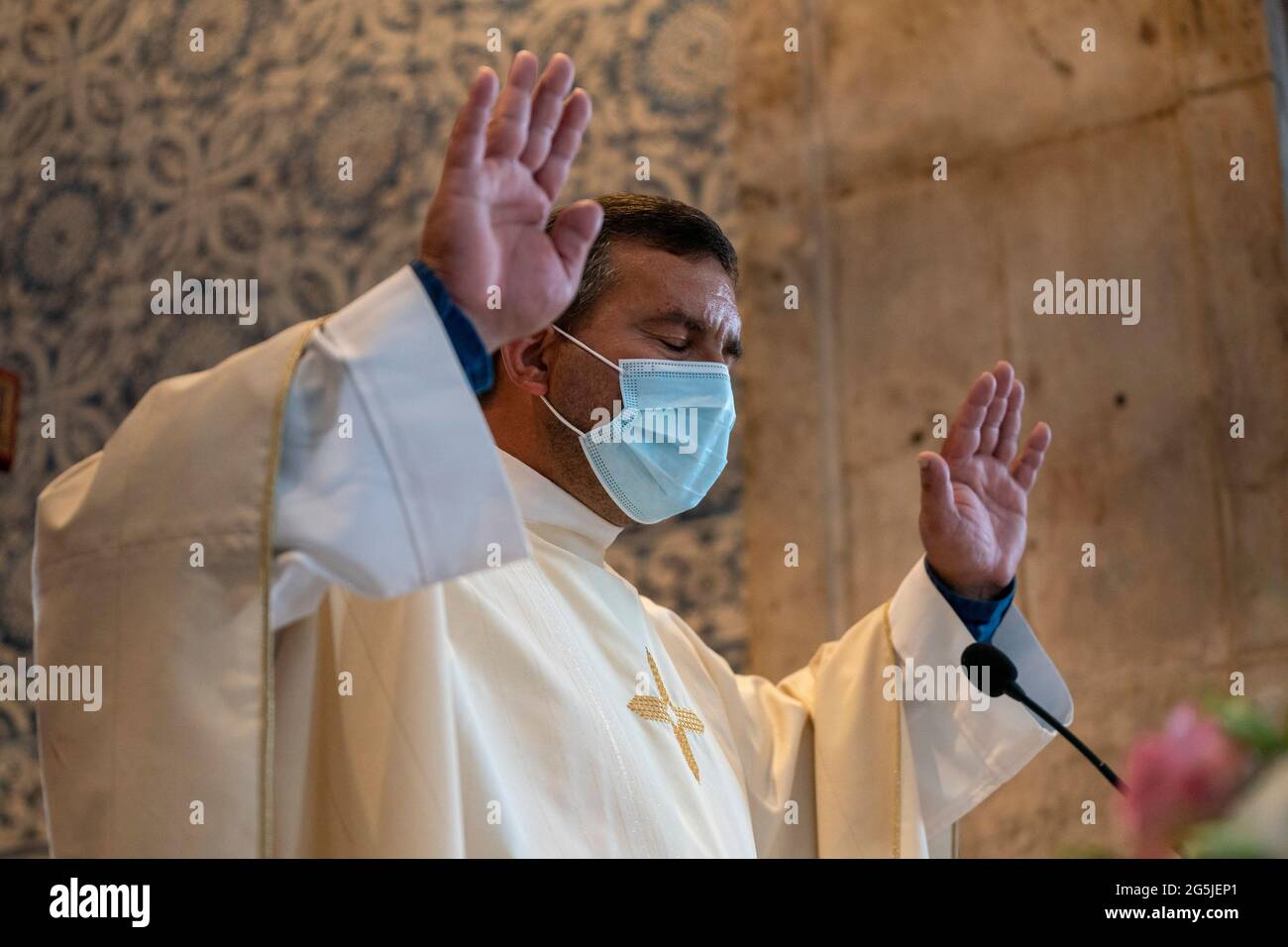 Sacerdote católico con máscara mientras celebra la misa durante la pandemia de COVID Foto de stock