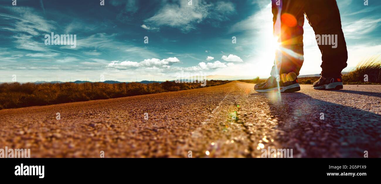 Estilo de vida Adventur y viajes extremos de vacaciones por carretera. Viaje hombre turista solo en la carretera y puesta de sol paisaje del desierto. Foto de stock