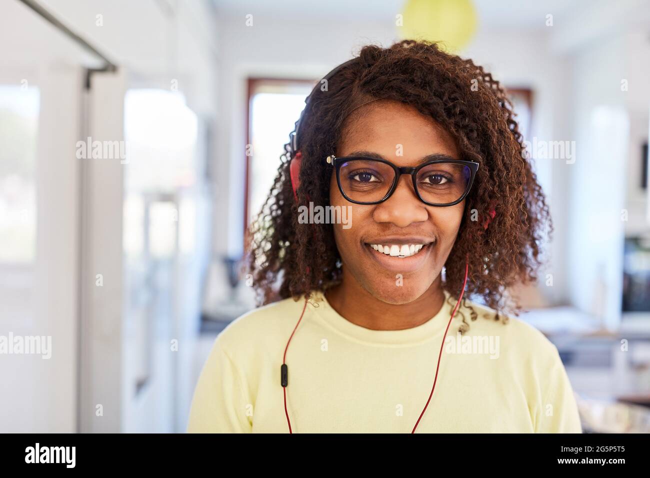 Mujer afroamericana con auriculares mientras transmite música en línea o en redes sociales Foto de stock