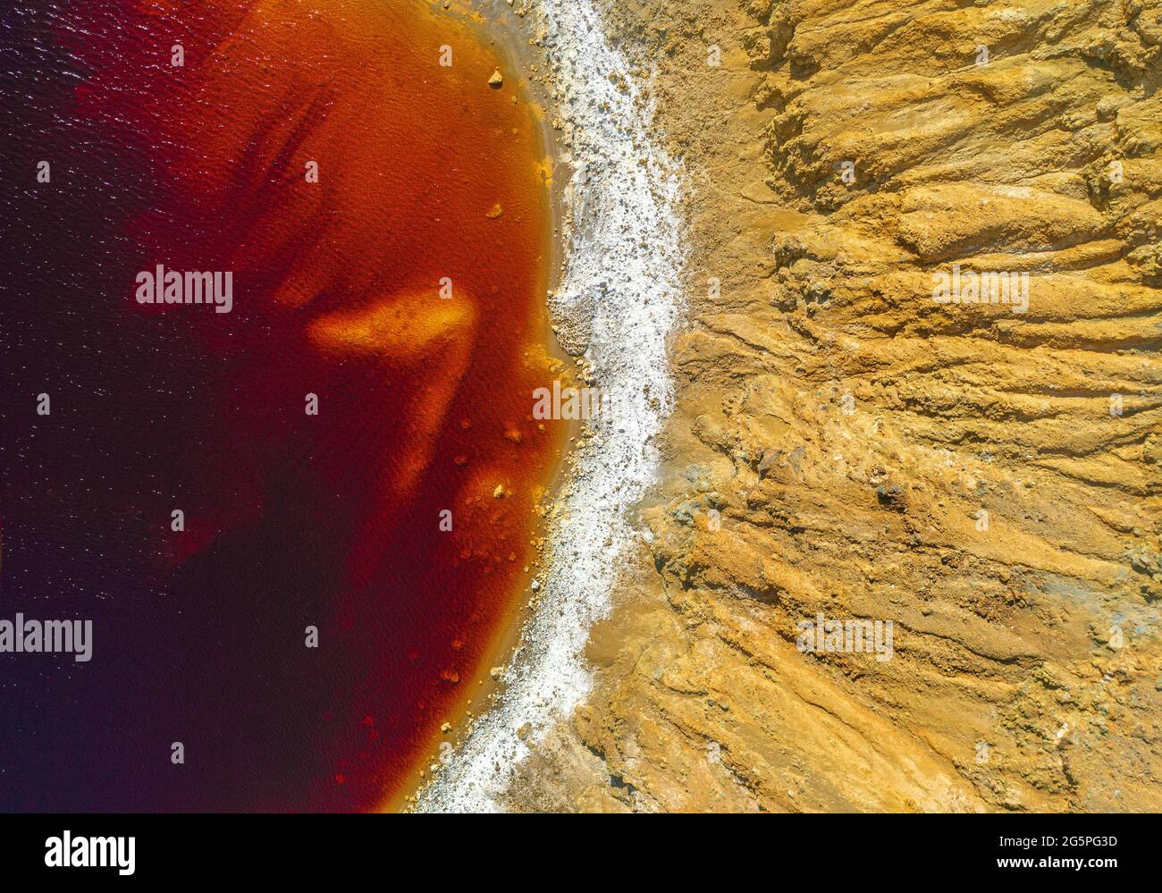 Orilla de un lago rojo tóxico en una mina de cobre a cielo abierto abandonada. Su color inusual es el resultado de la extracción de mineral de pirita en la zona Foto de stock