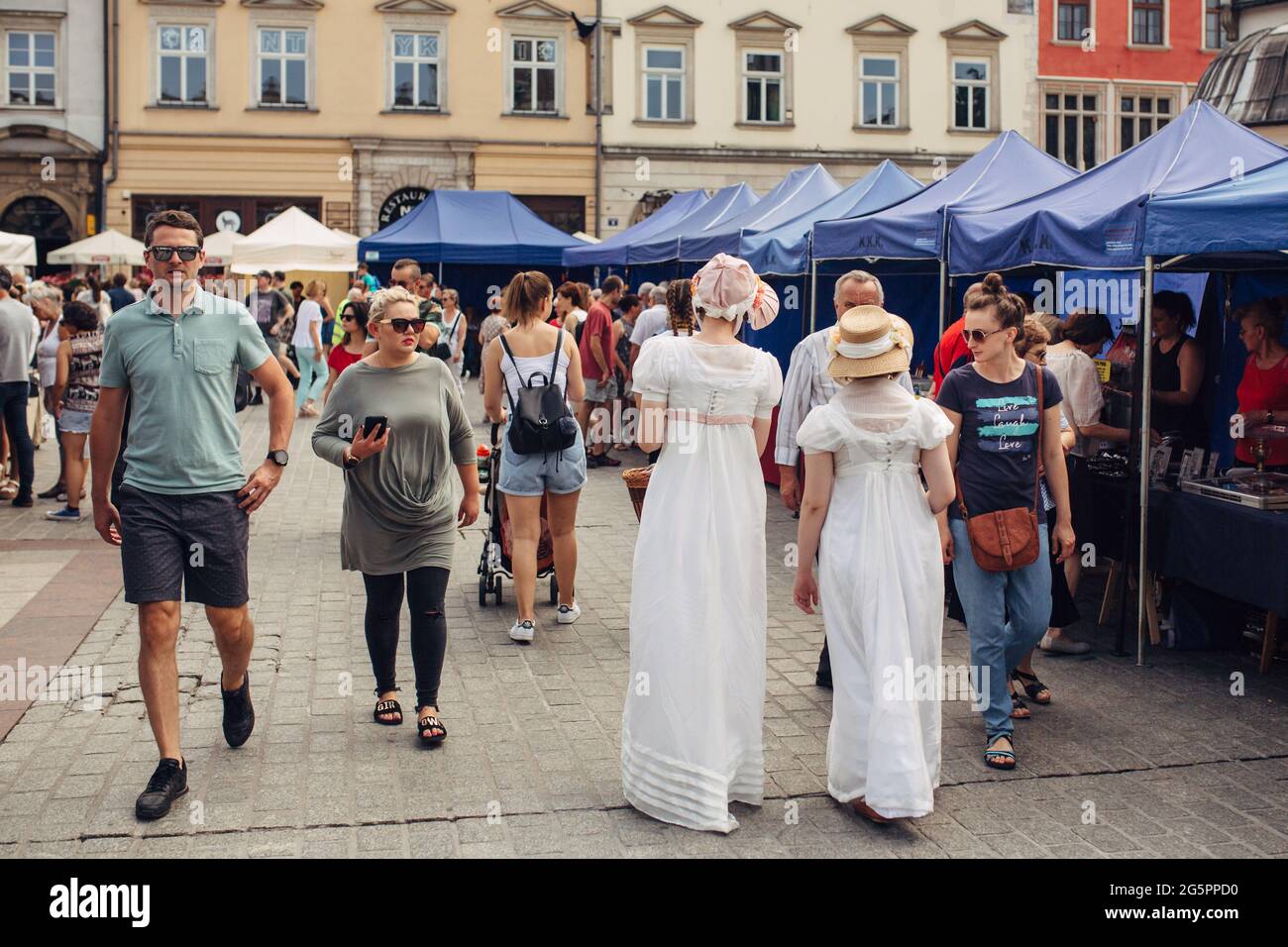 CRACOVIA, POLONIA - 21 de julio de 2019: Mujeres con vestidos blancos históricos caminando el casco antiguo de Cracovia, Polonia en verano, atracción turística y destino Fotografía de stock - Alamy