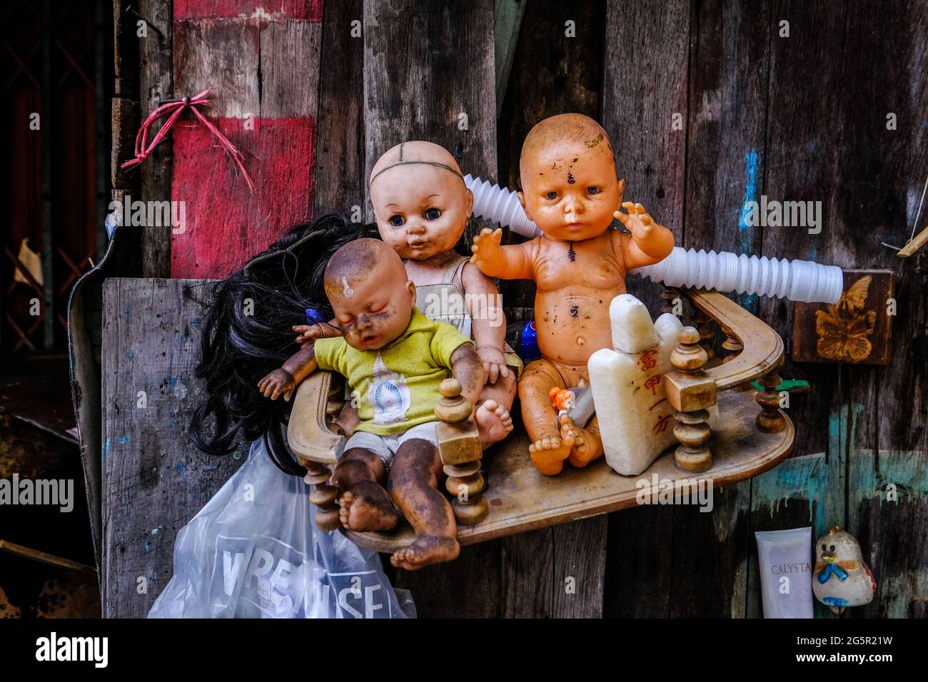 Tres muñecas siniestras se sientan en un estante de madera en un callejón  en Bangkok, Tailandia Fotografía de stock - Alamy