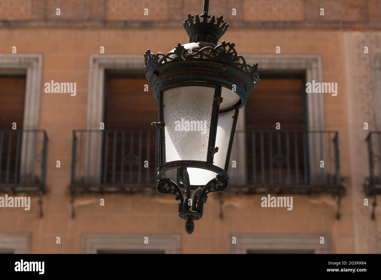 Segovia, España - 2 de junio de 2021: Una de las lámparas de hierro forjado de estilo clásico que cuelgan en las arcadas de la Avenida del Acueducto, en el centro de la ciudad Foto de stock