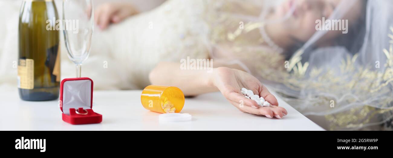 Novia acostada en el sofá con un puñado de píldoras en ella cierre de mano Foto de stock