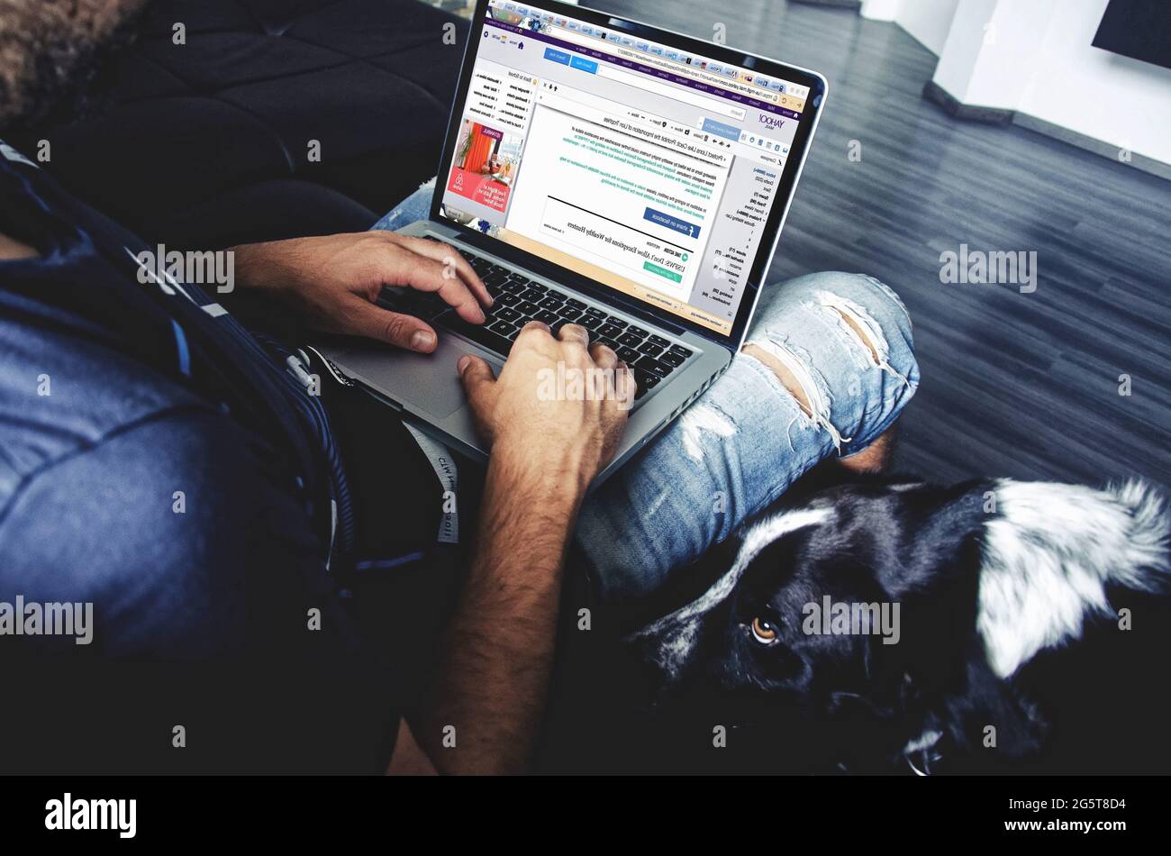 Hombre sentado en una silla para trabajar en una computadora, hombre blogging. Foto de stock