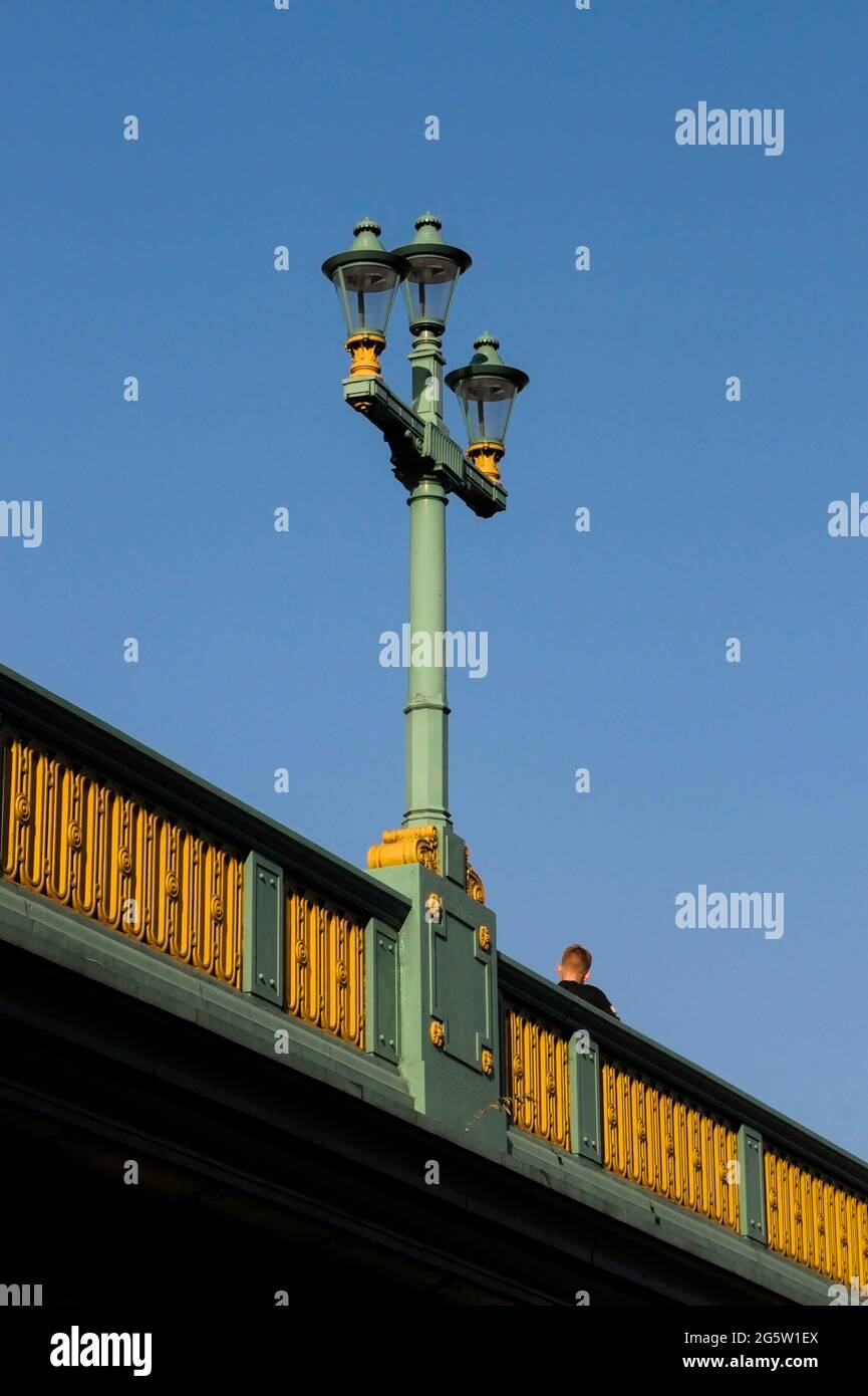 Joven en un puente de Londres con lámpara de calle Foto de stock