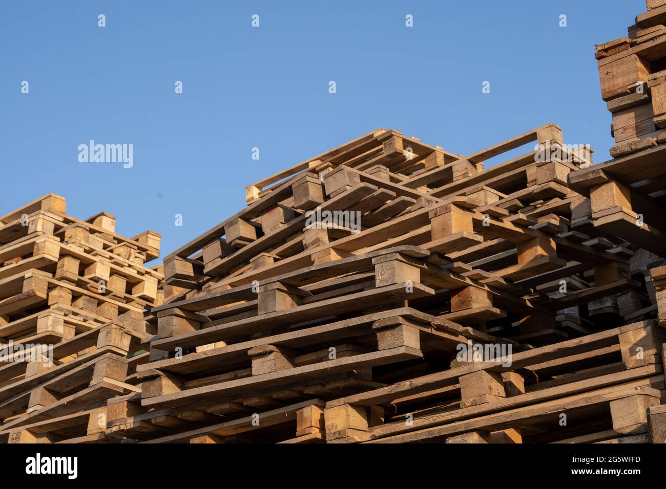 Palets de madera usados en la pila del almacén. Superposición de palets