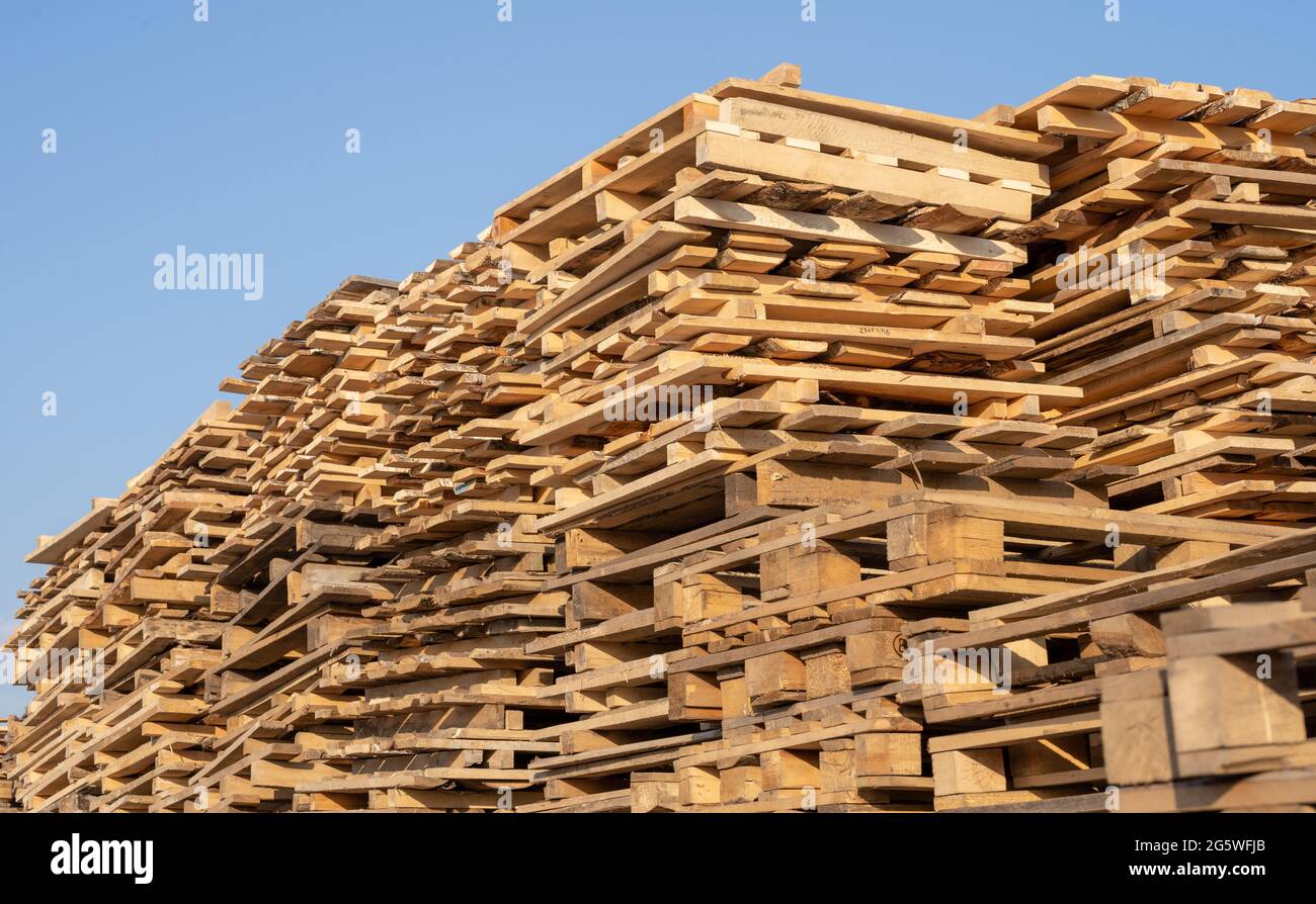 Palets de madera usados en la pila del almacén. Superposición de palets
