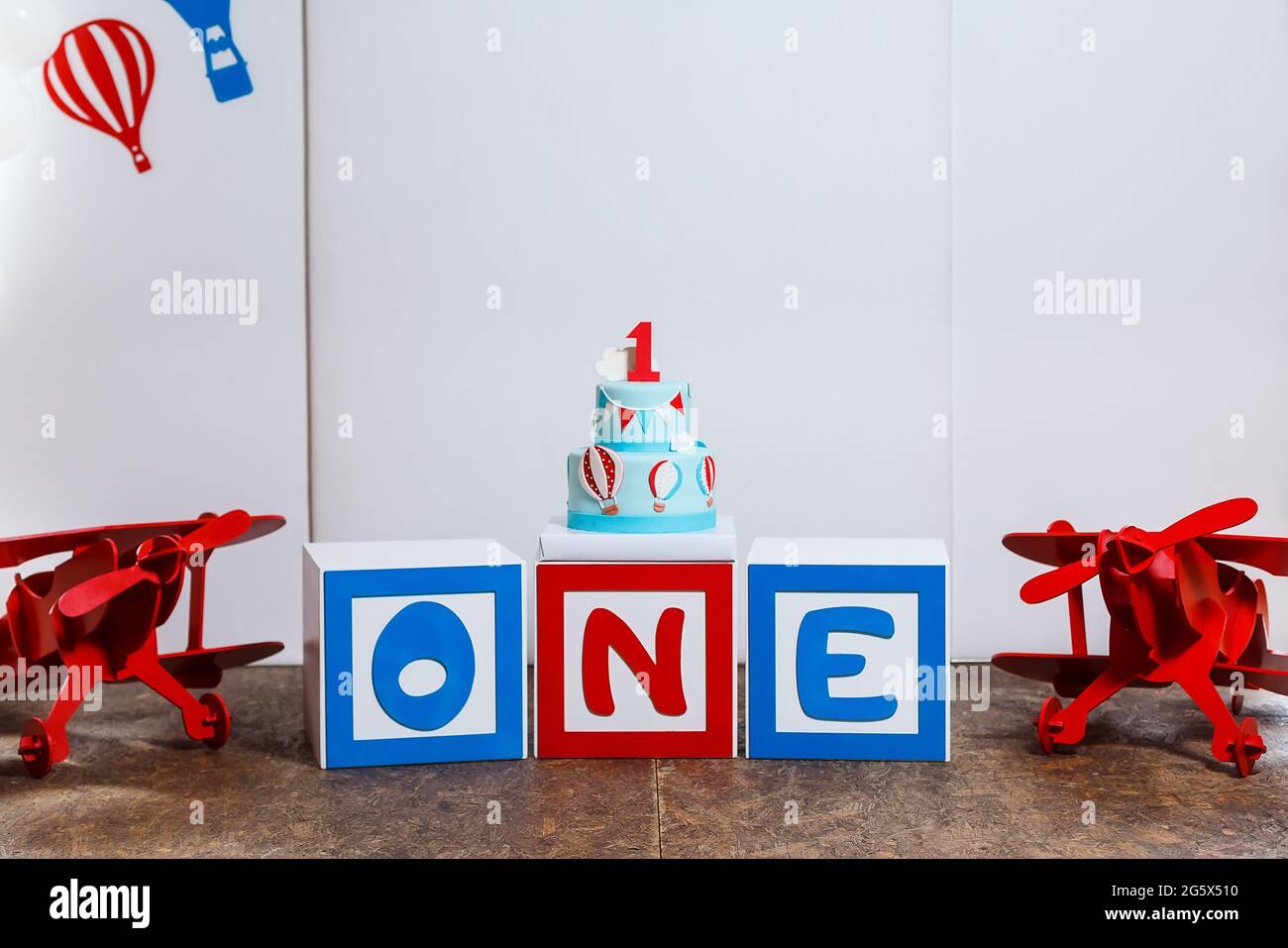 Zona de fotos en la primera fiesta de cumpleaños del niño con aviones y  pastel grande. Decorado en colores azul, rojo y blanco, globos o temática  de aviación, interior Fotografía de stock -