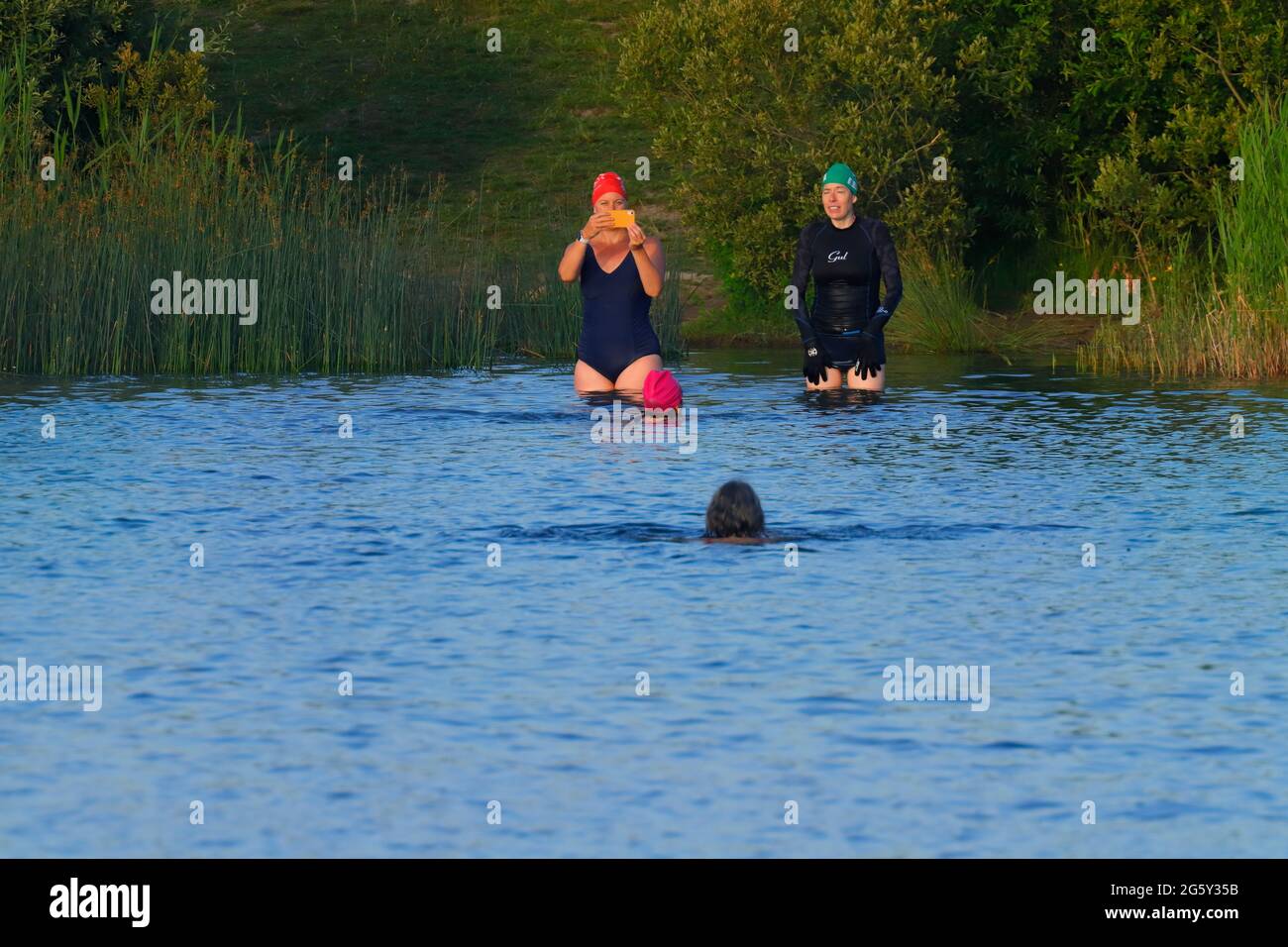 Nadadores en aguas abiertas en el RSPB St Aidan's Nature Park en Swillington, Leeds, West Yorkshire, Reino Unido Foto de stock
