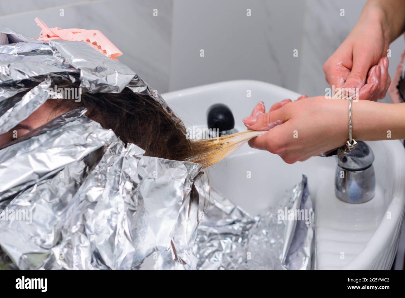 Lavado de tinte de cabello de una peluquería, quitar el papel de aluminio  del cabello. Nuevo Fotografía de stock - Alamy