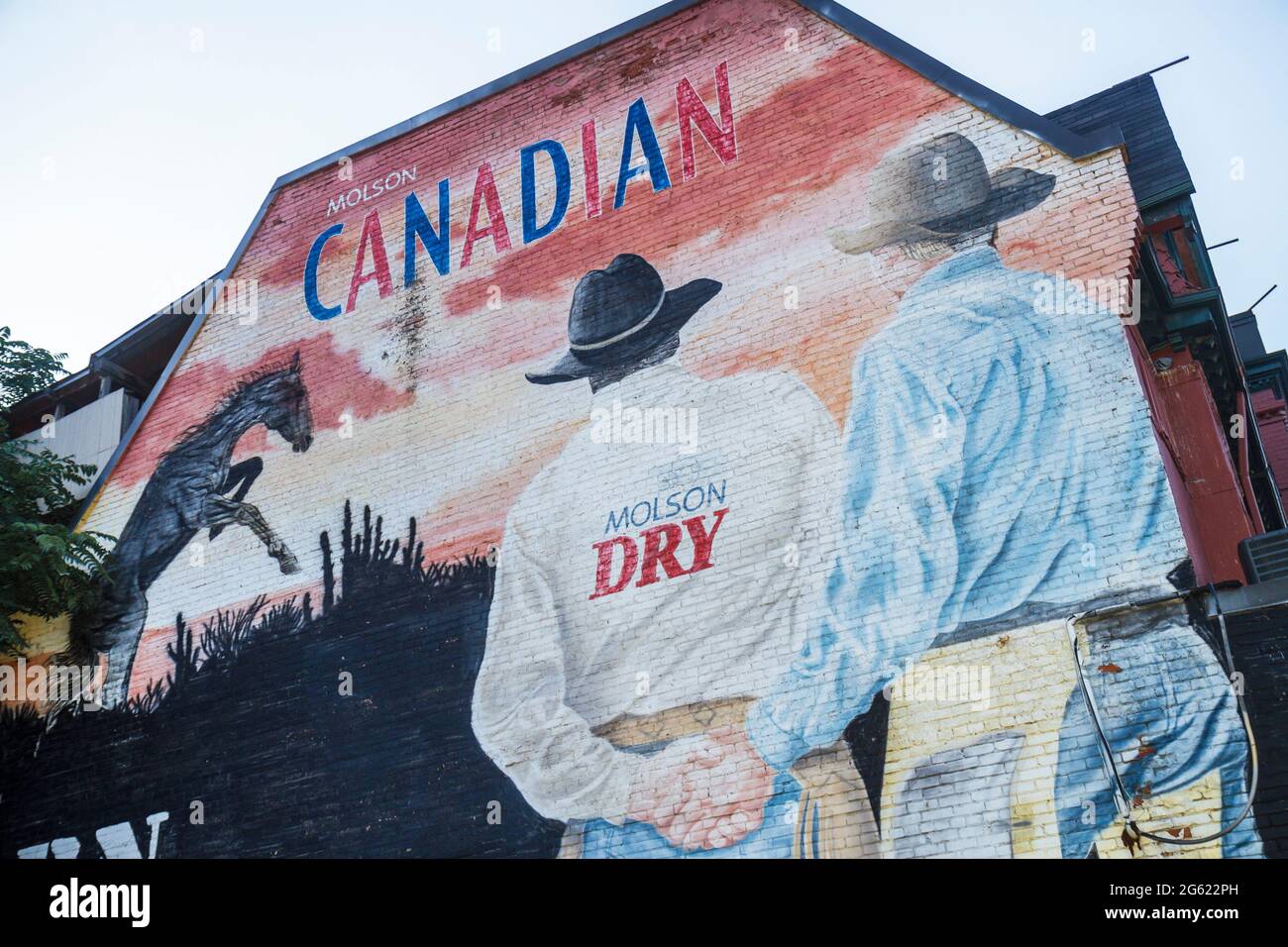 Toronto Canadá,Church Street,edificio,mural de pared,Molson Coors Brewing Company,compañía canadiense,cerveza,anuncio,apuntado,vaquero,hombres,sosteniendo mano,manos,amigo gay Foto de stock
