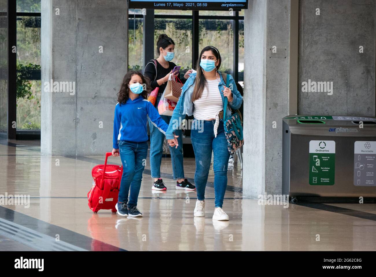 Medellín, Antioquia, Colombia - 17 2021: Madre con su hijo Lleve máscaras y camine con sus maletas en el Aeropuerto María Cordova Termin Fotografía de stock - Alamy
