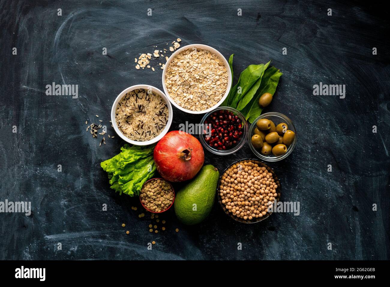 Selección de súper alimento saludable en la superficie de la pizarra con  fruta, cereales y hierbas Fotografía de stock - Alamy