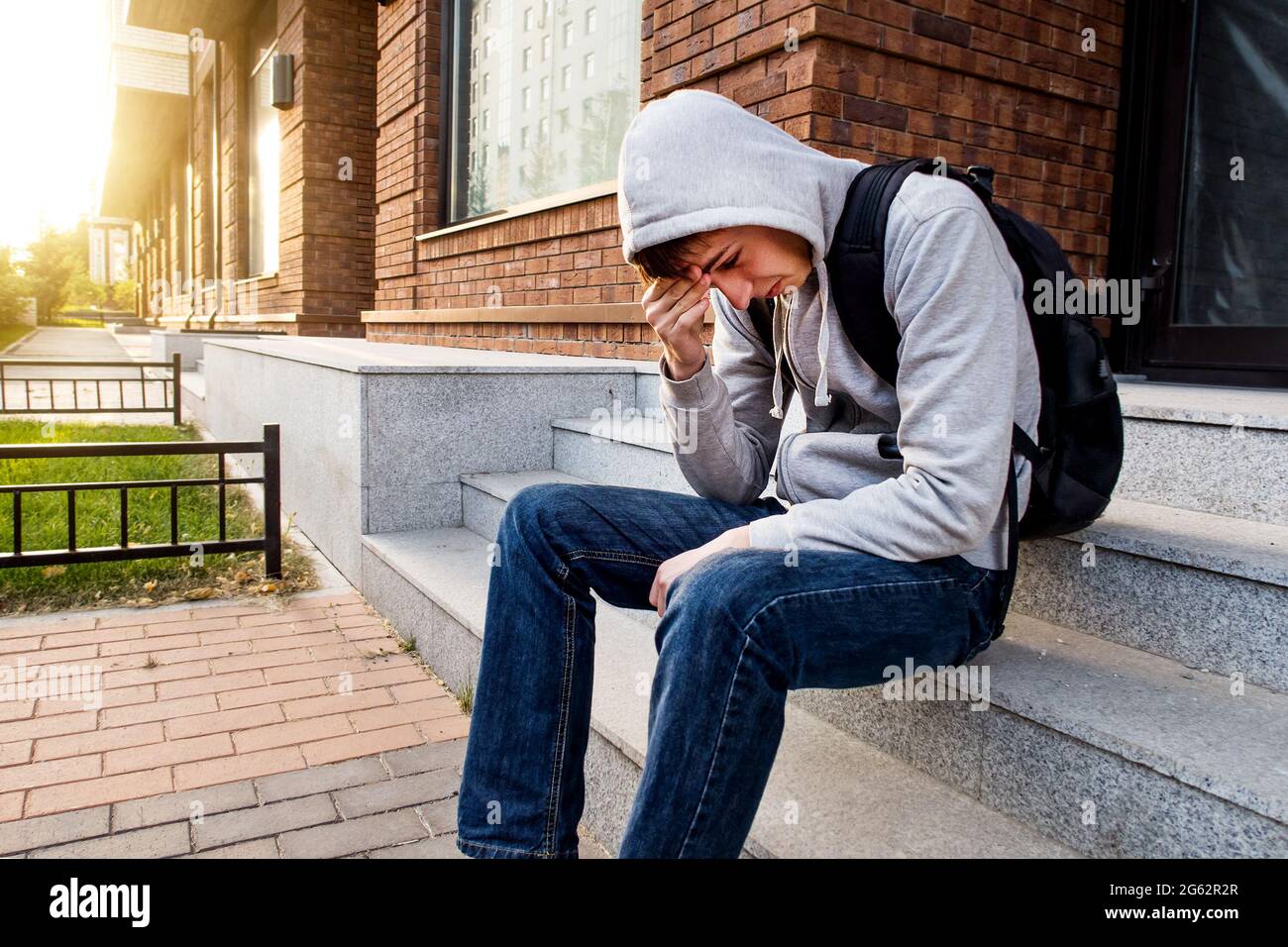 Triste joven hombre en una con capucha Siéntate ciudad Calle Fotografía de - Alamy