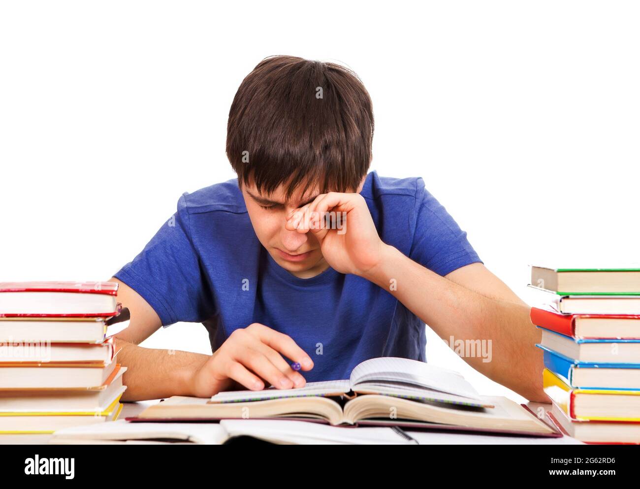 Estudiante cansado frotar los ojos en el Escritorio de la Escuela aislado Sobre el fondo blanco Foto de stock