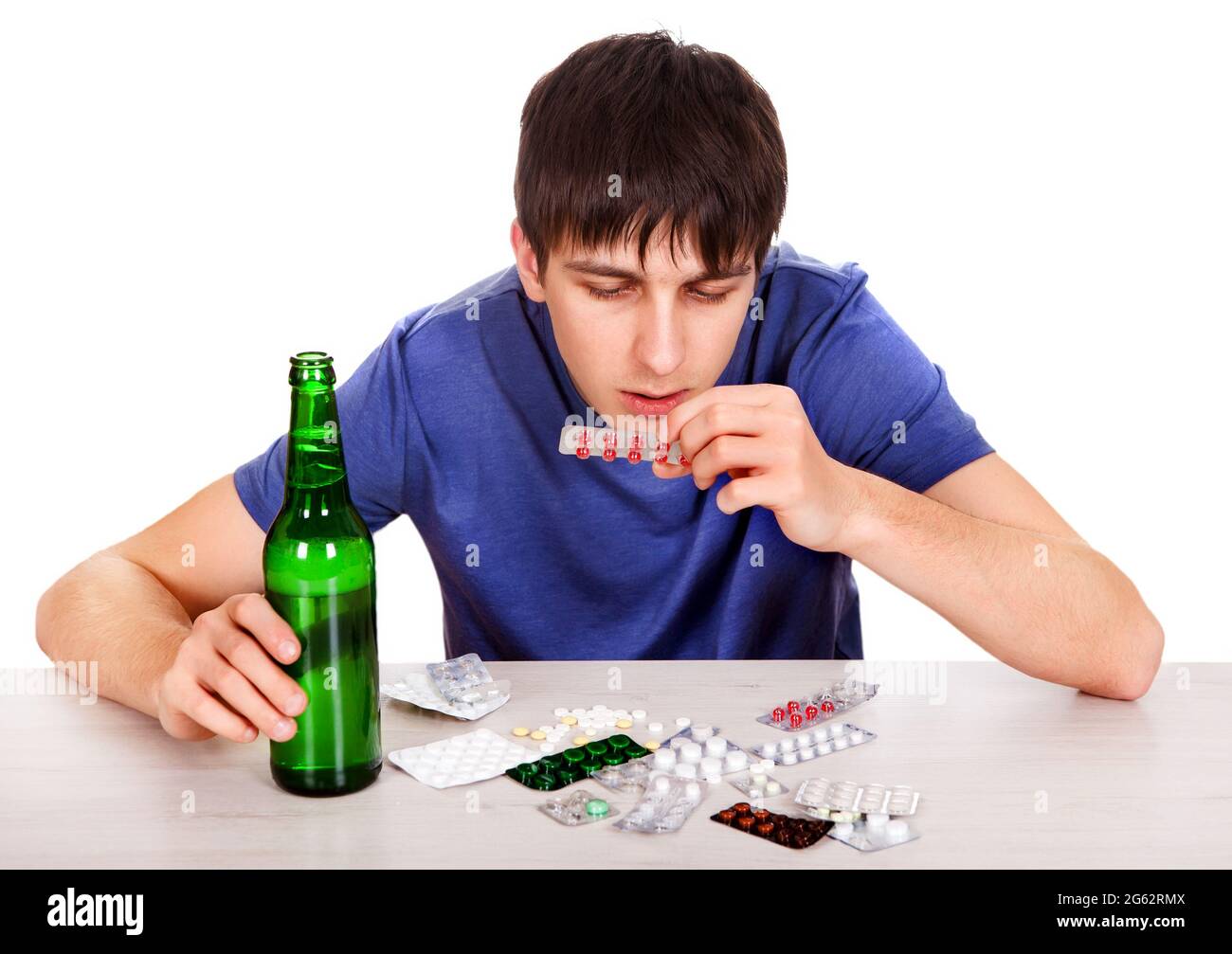 Hombre joven con pastillas y botella de la cerveza En la mesa Fotografía de  stock - Alamy