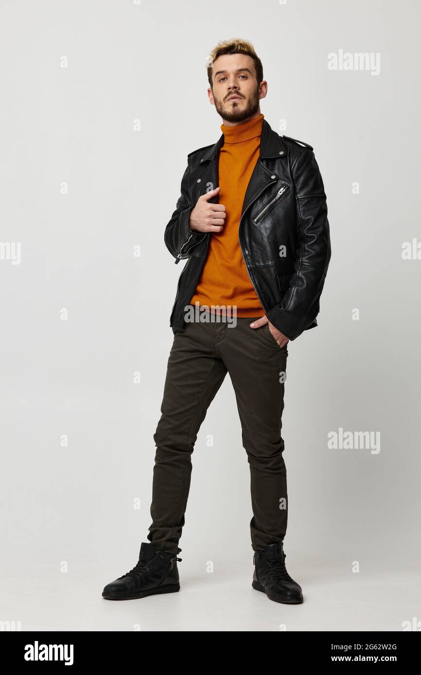 hombre con estilo en una chaqueta de cuero naranja mirar directamente a un fondo claro Fotografía stock Alamy