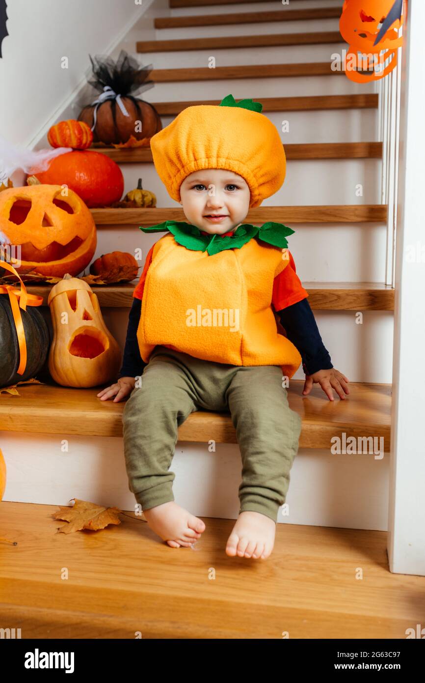 Lindo bebé sonriente vestido como calabaza mirando la cámara Fotografía de  stock - Alamy