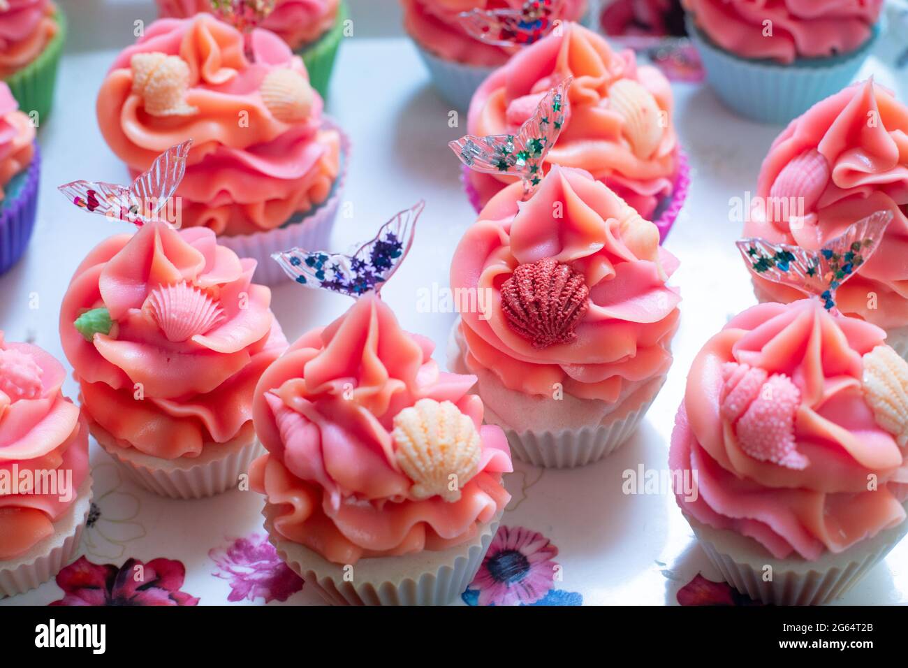 macro tiro de coloridos jabones de panadería con cupcake con hielo naranja  rosa con conchas pequeñas y cola de sirena de resina transparente hecha  para la industria del hogar Fotografía de stock -