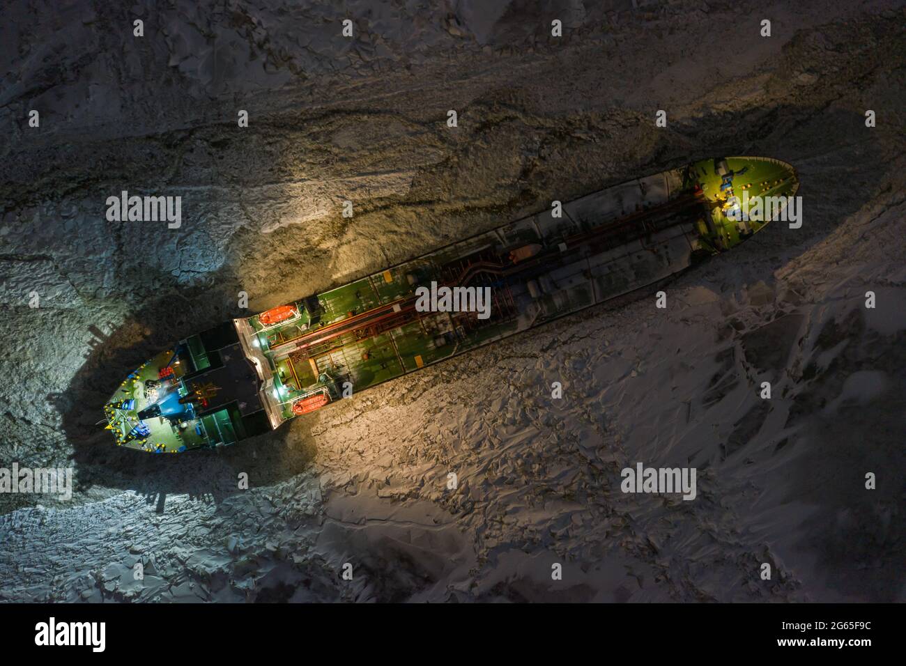 Sabetta, región de Tyumen, Rusia - 04 de diciembre de 2020:El buque tanque está congelado en hielo esperando el rompehielos. La nave brilla con todas las luces de noche Foto de stock