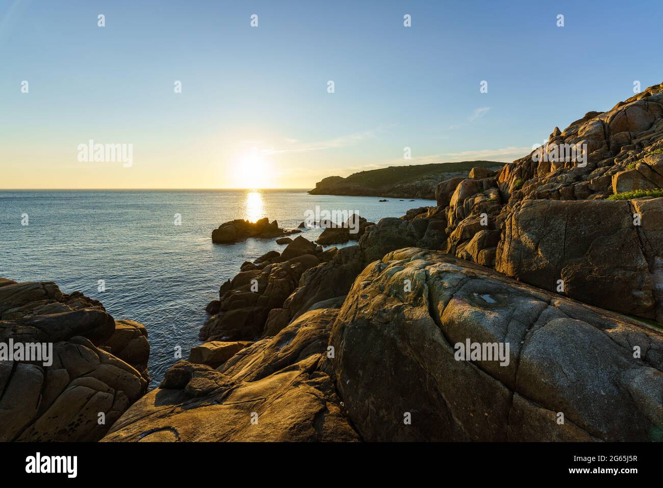 Escena de tranquilidad. Puesta de sol sobre el mar tranquilo, Océano Atlántico, Galicia, España Foto de stock