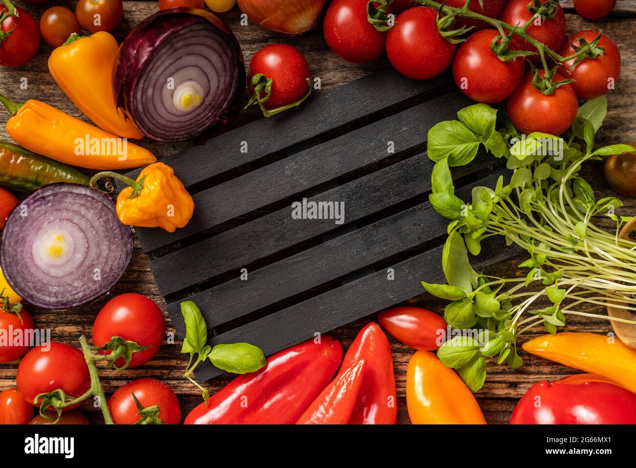 Deliciosas verduras servidas alrededor en la paleta a rayas negras Foto de stock