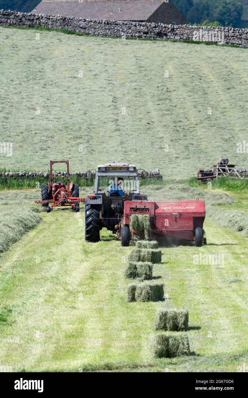 Empacar pequeñas pacas de Hay con una empacadora New Holland y un tractor  Massey Ferguson en un prado, Hawes, North Yorkshire, Reino Unido Fotografía  de stock - Alamy