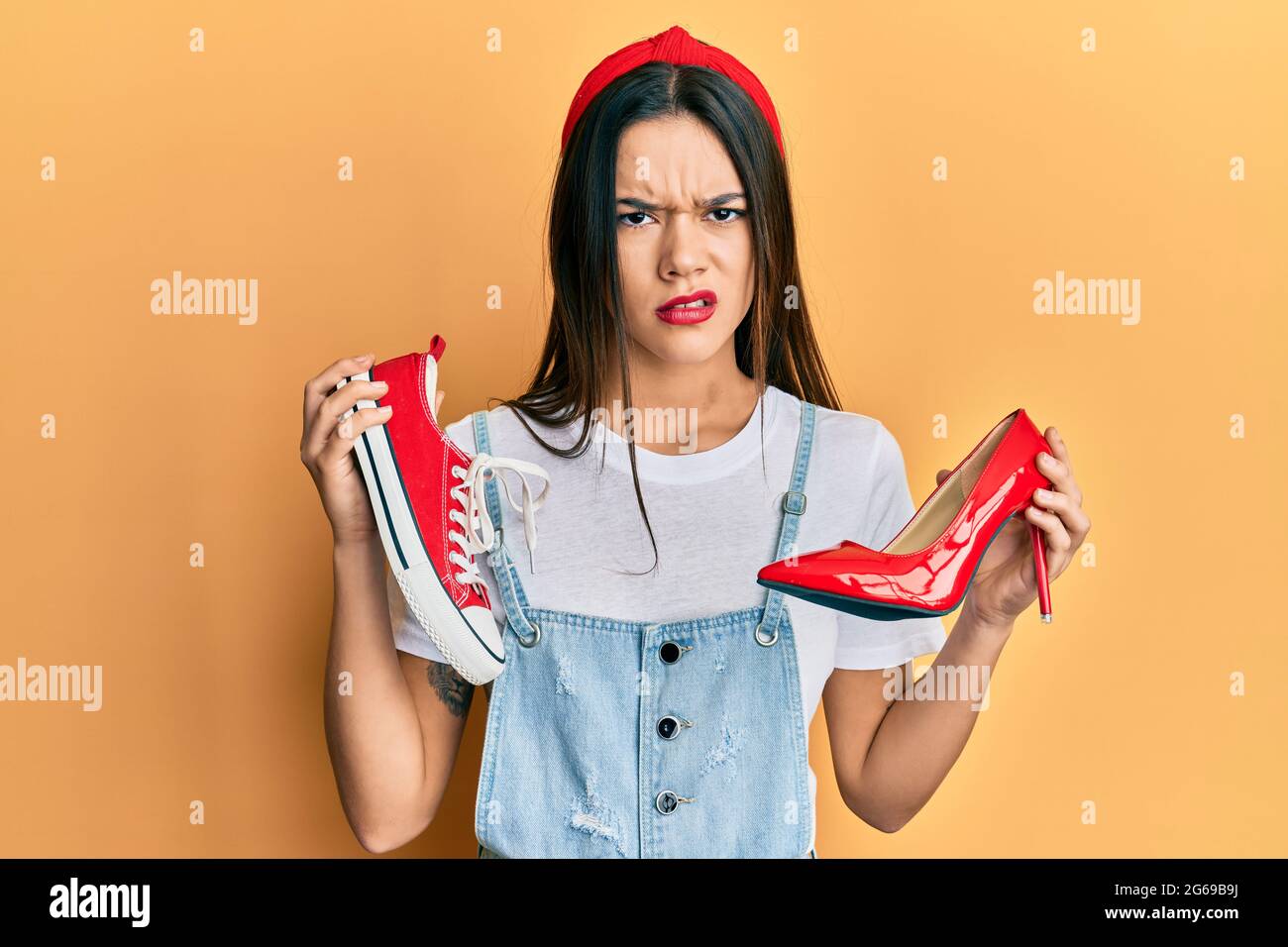 Joven hispana escogiendo zapatos y zapatillas altas de tacón escéptico y  nervioso, desenfadado por problemas. Persona negativa Fotografía de stock -  Alamy