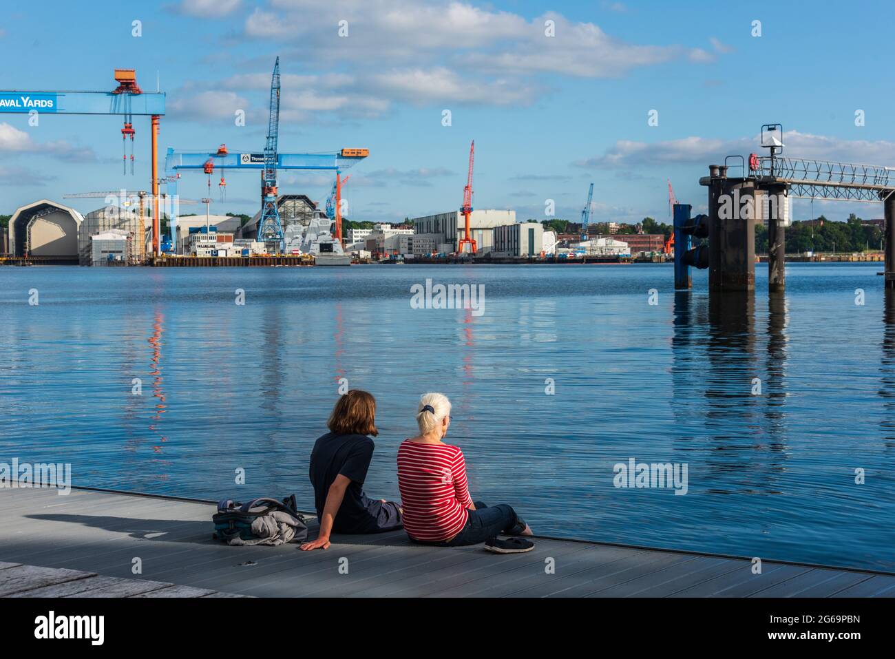 Zwei Frauen auf dem Anleger eines Kieler Ruderclubs an der Kiellinie an einem sommerlichen Abend Foto de stock