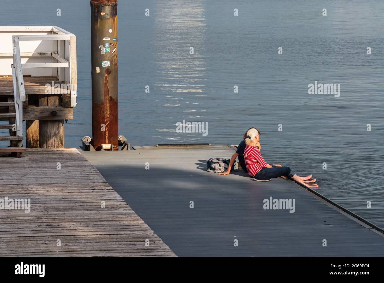 Zwei Frauen auf dem Anleger eines Kieler Ruderclubs an der Kiellinie an einem sommerlichen Abend Foto de stock