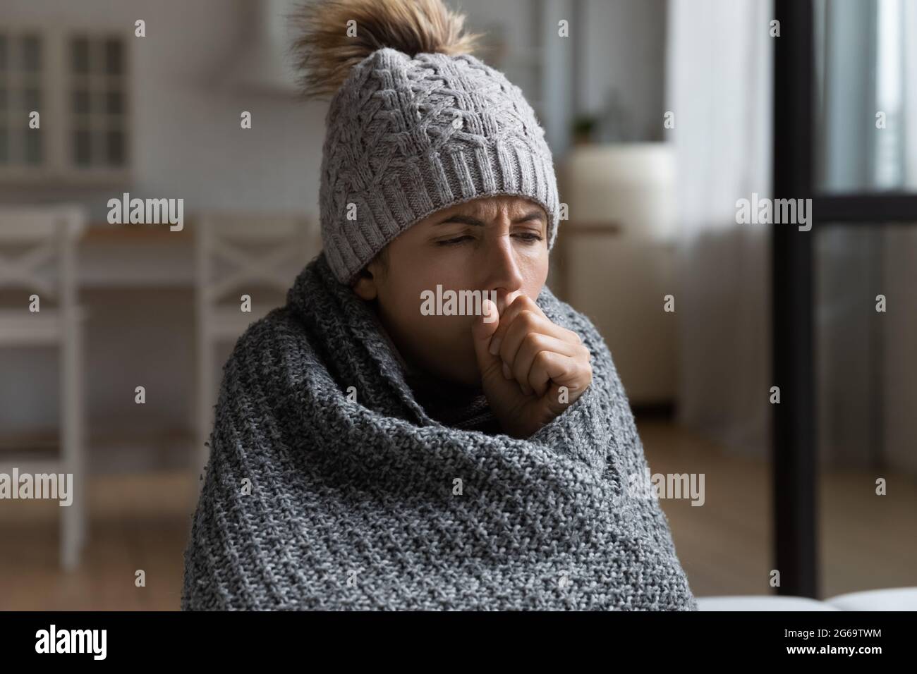 Malsana mujer hispana milenaria tosiendo, sintiéndose mal. Foto de stock