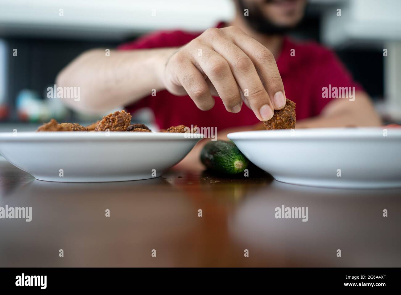 Niño árabe comiendo falafel casero adentro Foto de stock
