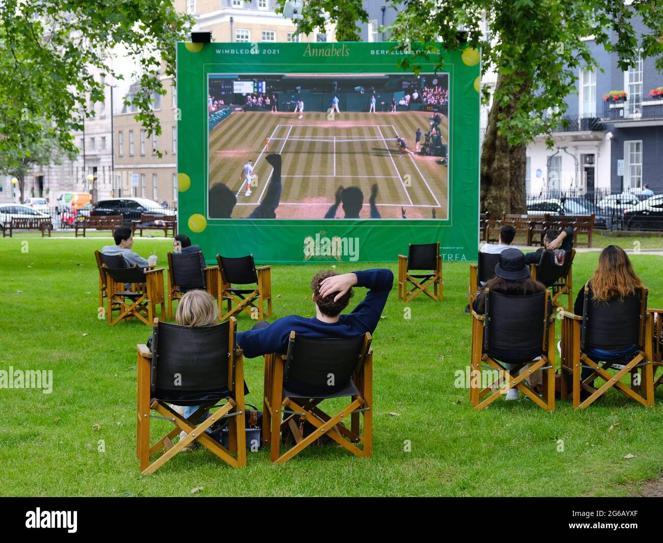 La gente disfruta de proyecciones públicas del torneo de tenis de Wimbledon en Berkerley Square en Mayfair, como una de las muchas pantallas al aire libre en la capital Foto de stock