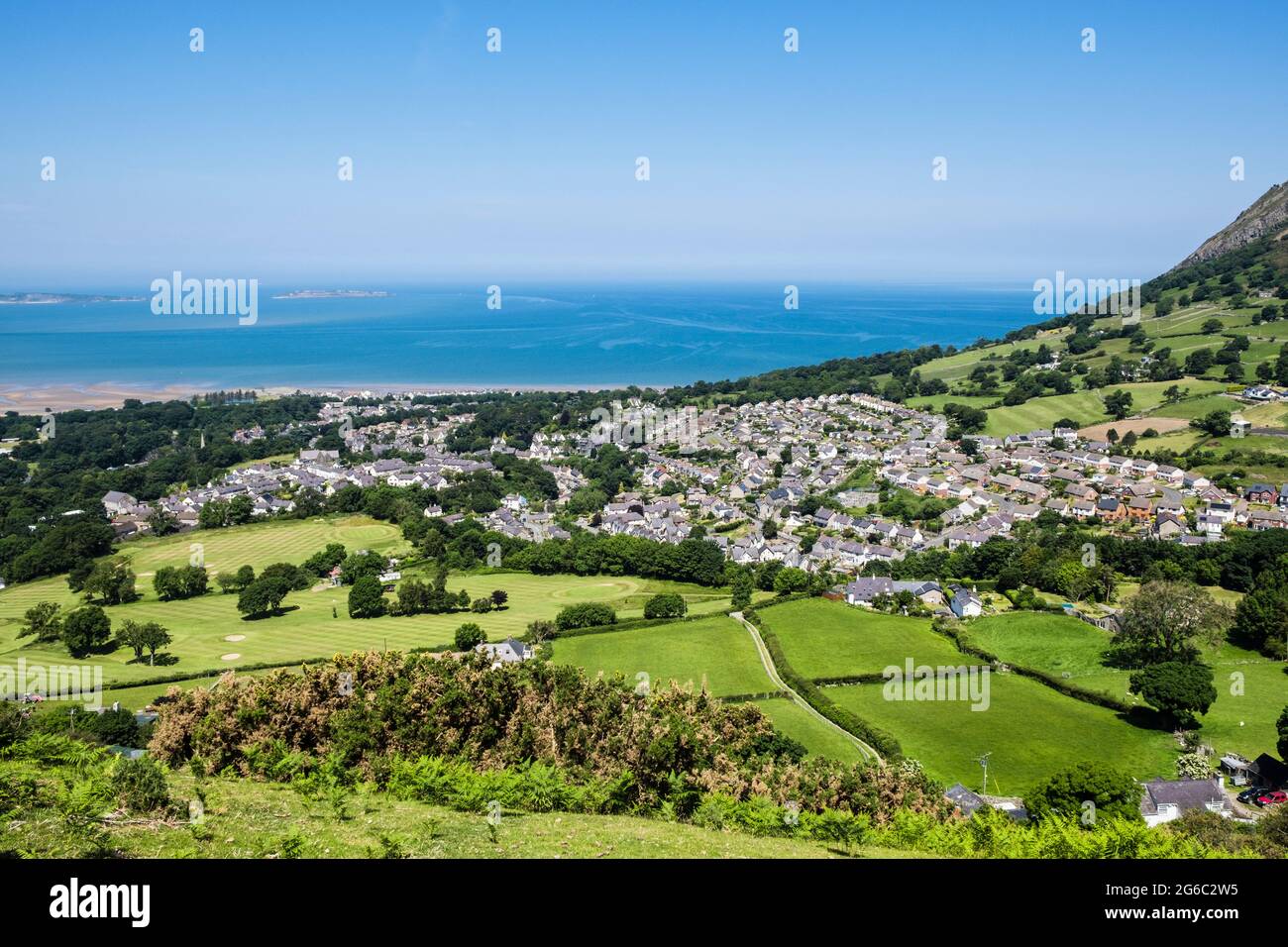 Vista alta al pueblo en la costa norte de Gales desde las colinas en el borde norte de Snowdonia. Llanfairfechan, Conwy, norte de Gales, Reino Unido, Gran Bretaña Foto de stock