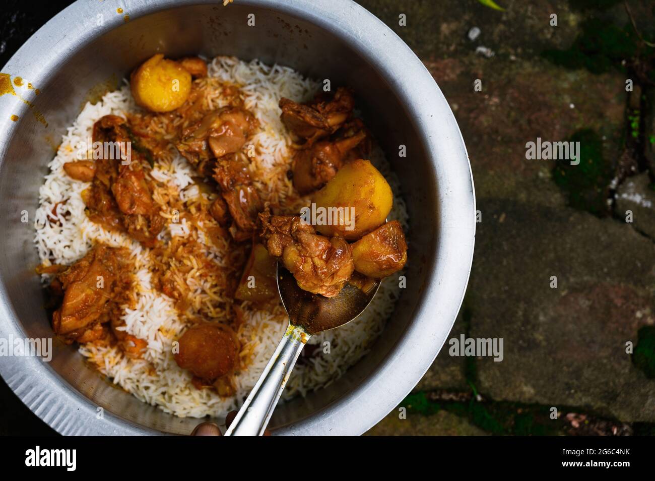 Una mujer está cocinando biryani. Biryani es una palabra indoaria derivada  de la palabra persa 'Birian', que significa 'frito antes de cocinar' y  'Birinj', la palabra persa para el arroz. El Biryani