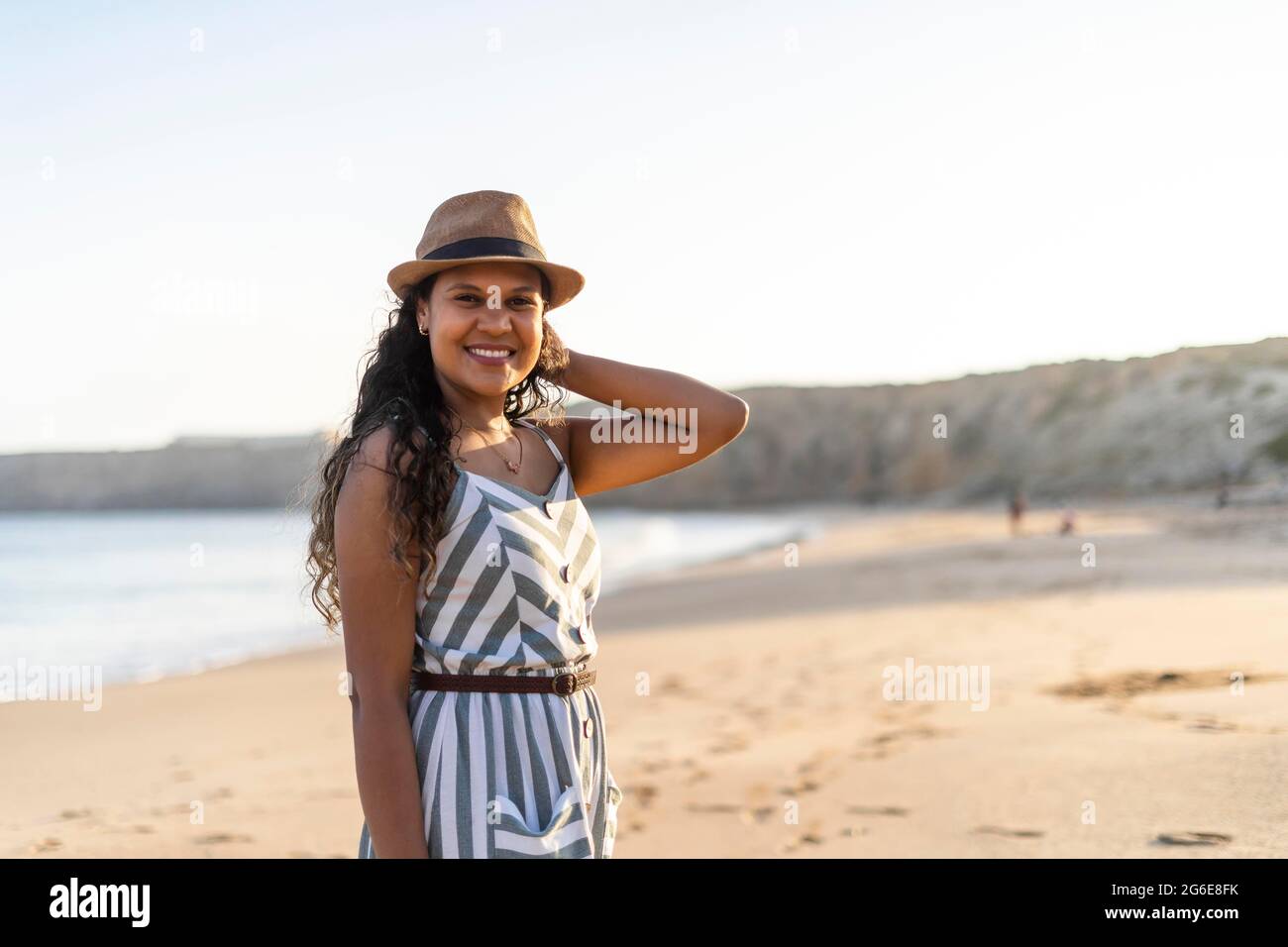 Retrato de una hermosa mujer joven en la playa al atardecer en Algarve, Portugal Foto de stock