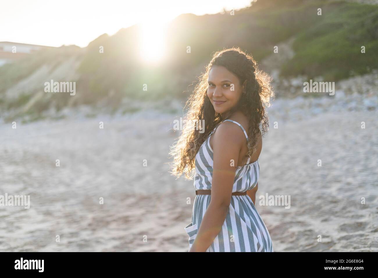 Retrato de una hermosa mujer joven en la playa al atardecer en Algarve, Portugal Foto de stock