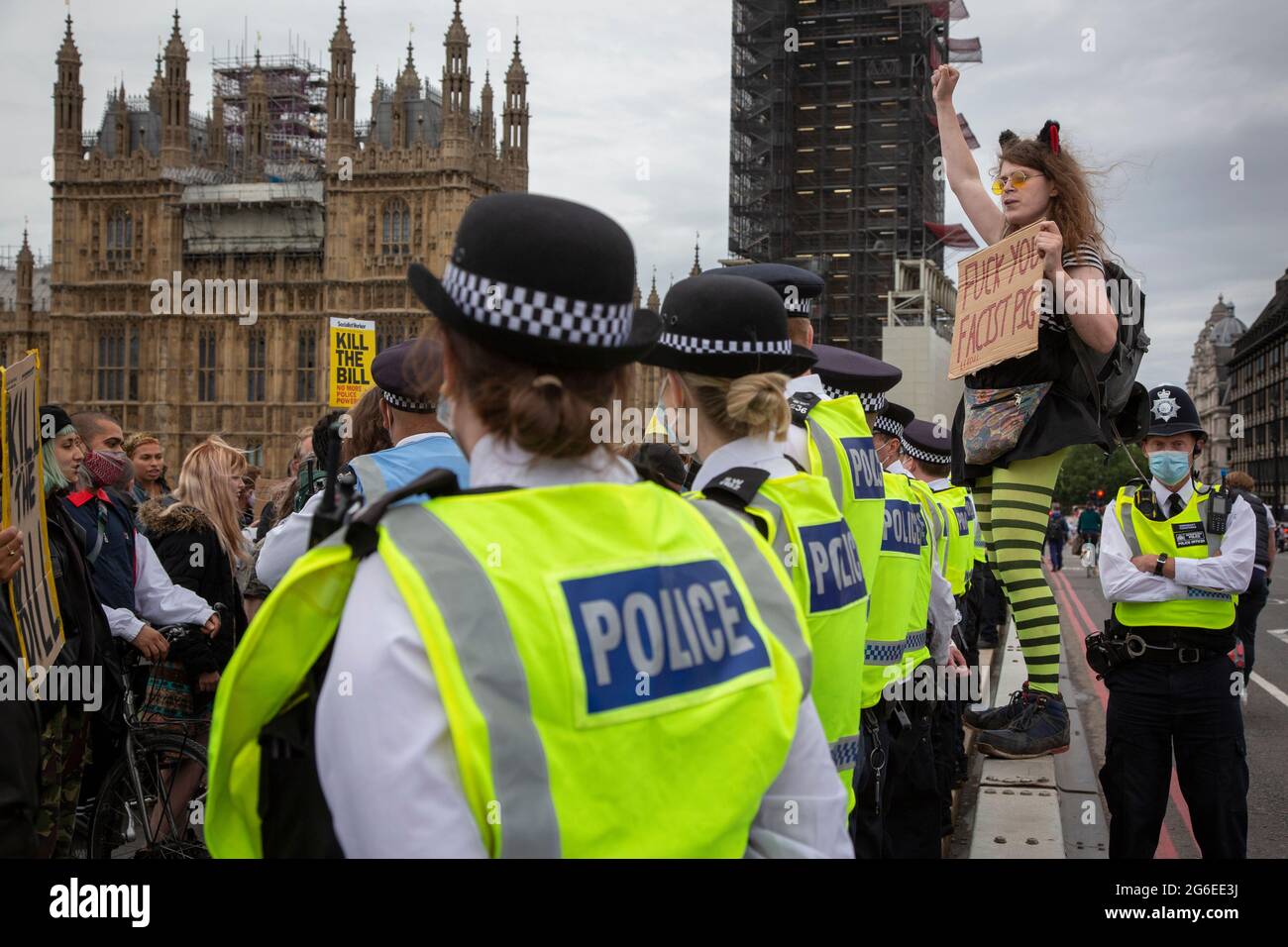 Un joven manifestante con orejas de gato y gafas amarillas sostiene un letrero en medio de la policía en la protesta 'Kill the Bill' en el centro de Londres, 5.7.2021 Foto de stock