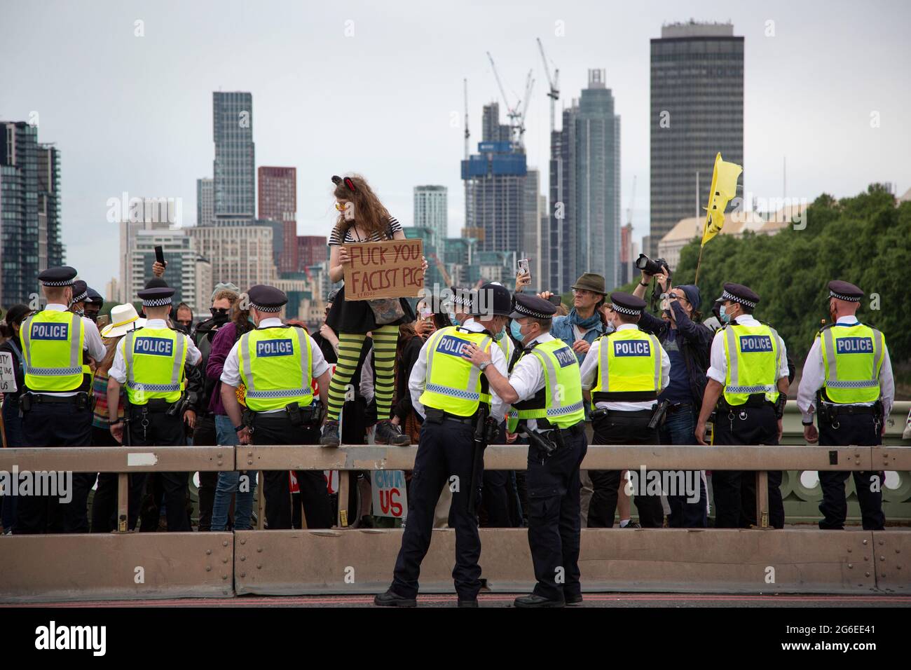Un joven manifestante con orejas de gato y gafas amarillas sostiene un letrero en medio de la policía en la protesta 'Kill the Bill' en el centro de Londres, 5.7.2021 Foto de stock