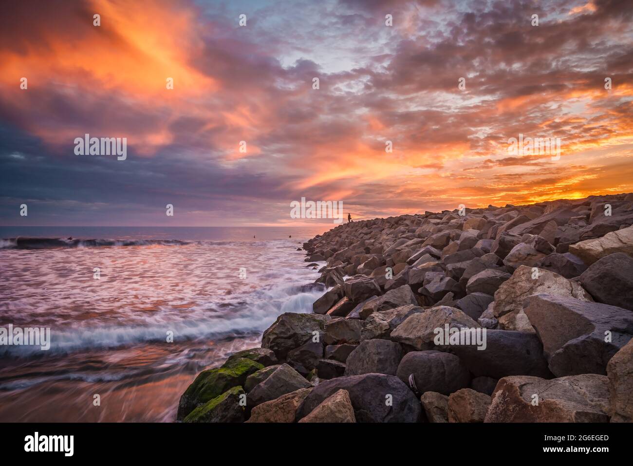 Larga exposición surf a lo largo de un muelle de playa al atardecer Foto de stock