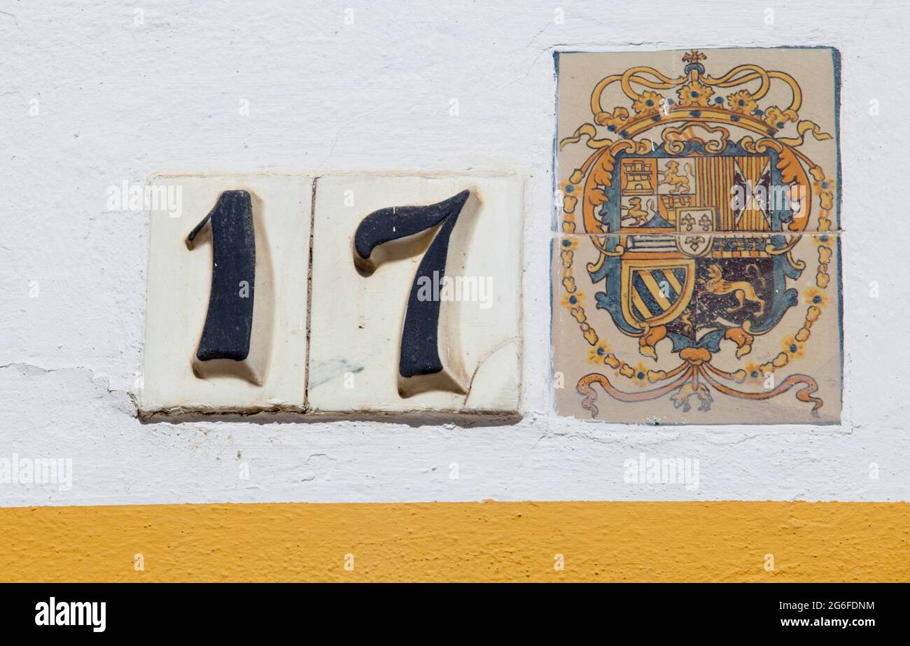 Alcázares Reales de Sevilla. Escudo de armas de azulejos y 17 puertas número de Patio de Banderas sección. Foto de stock