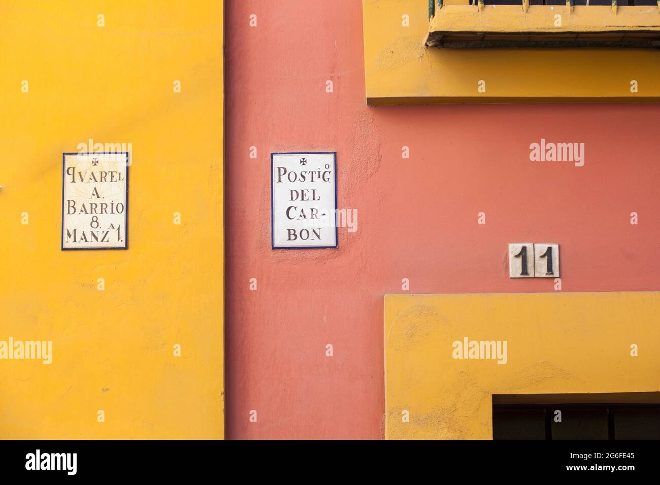 Coloridas casas pintadas por la estrecha calle del barrio de Santa Cruz, distrito histórico de Sevilla, España. Foto de stock