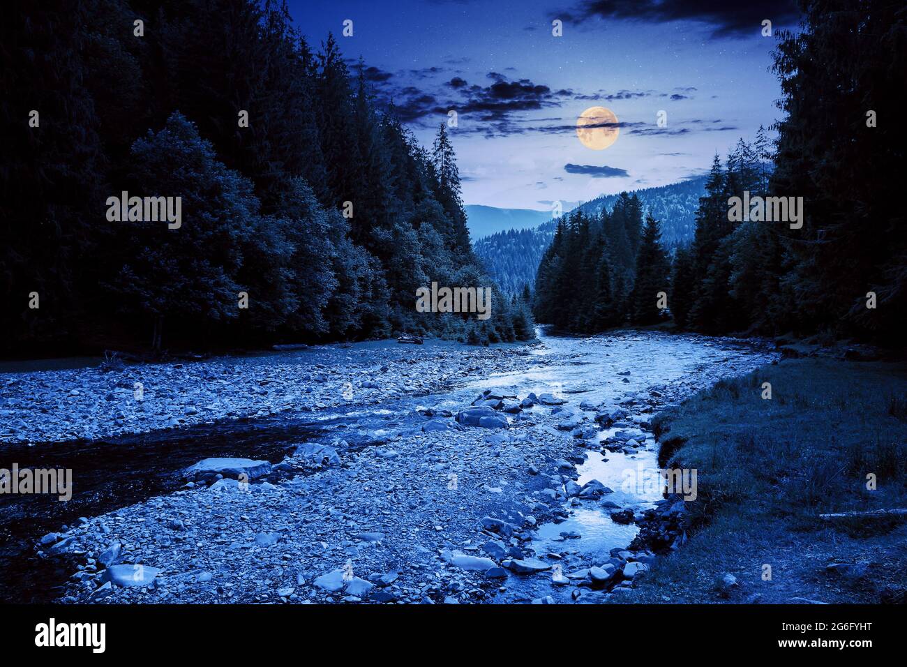 el río de montaña corre a través de un valle boscoso. paisaje campestre en una noche de verano. árboles y piedras en la orilla a plena luz de la luna Foto de stock