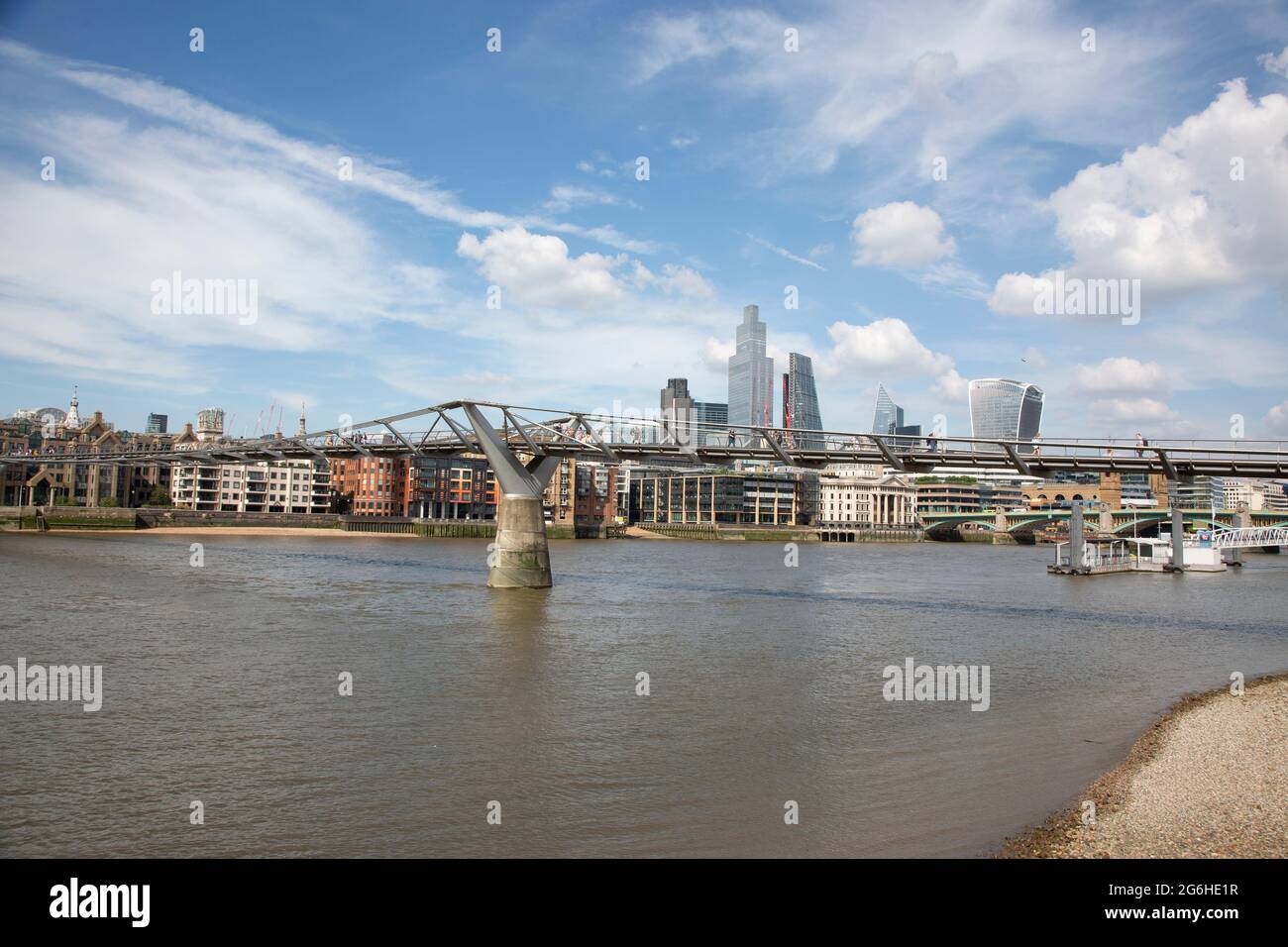 El Millenium Bridge, diseñado por el arquitecto Norman Foster con el horizonte de la ciudad de Londres en la distancia. Londres, Reino Unido. Foto de stock