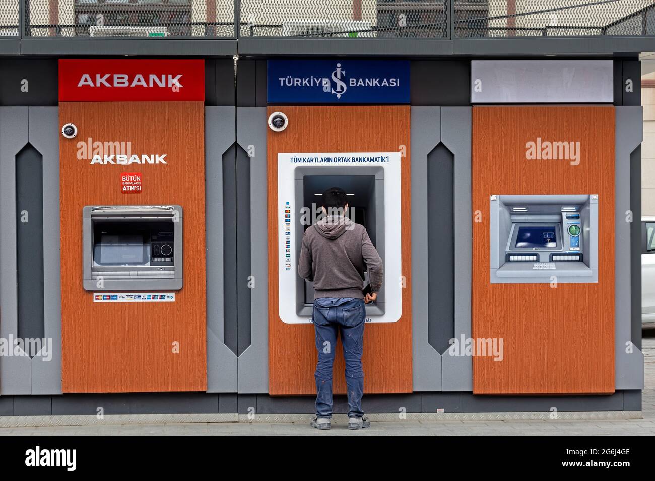 Hombre con vestido casual delante de Akbank, banco Isbank ATM s, retirada de dinero. Karakoy, Estambul - Turquía. Foto de stock
