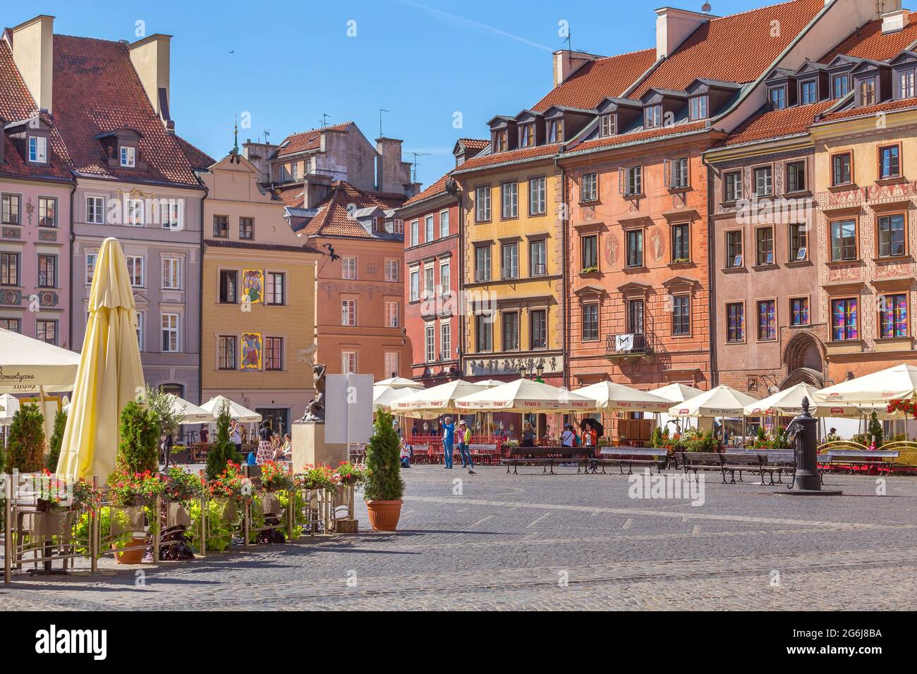 Varsovia, Polonia - Junio 24, 2019: Cafe con flores y coloridas casas en la plaza del mercado en el casco antiguo de la capital polaca Foto de stock